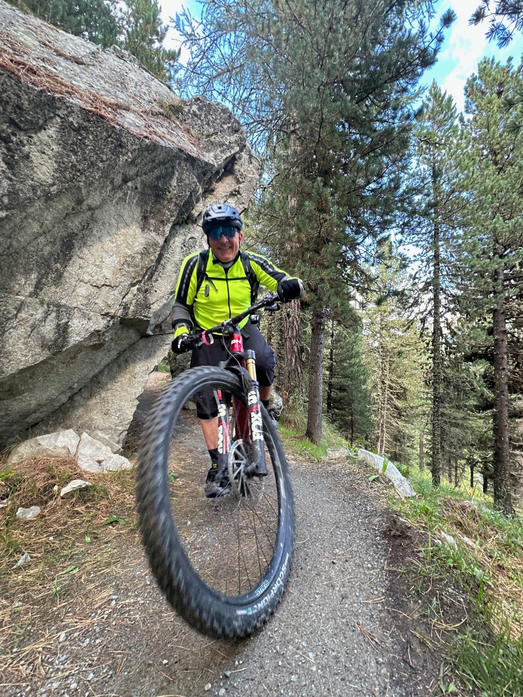 Alexis lachend neben einem Felsblock