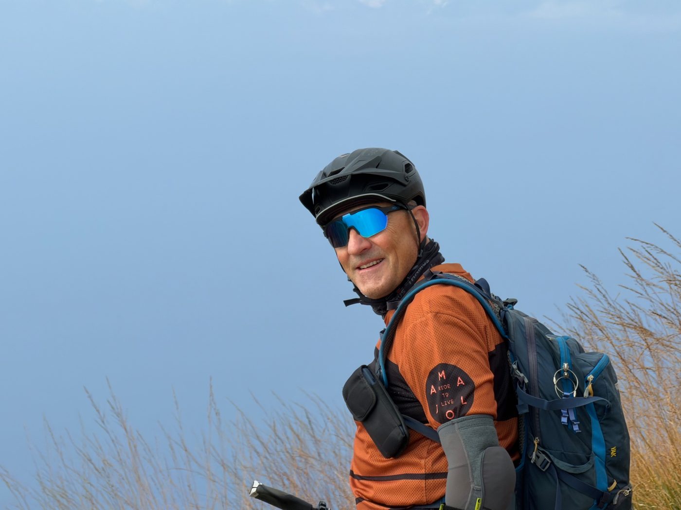 Alexis lachend mit Helm vor blauem Himmel