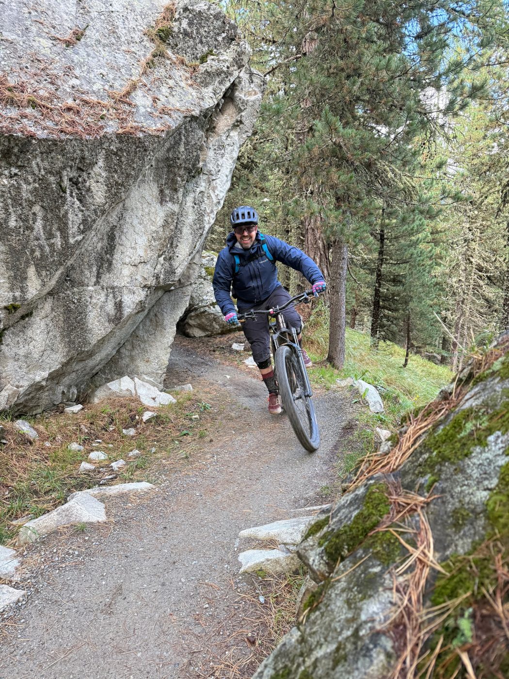 Roman lachend auf dem Bike neben einem Felsblock
